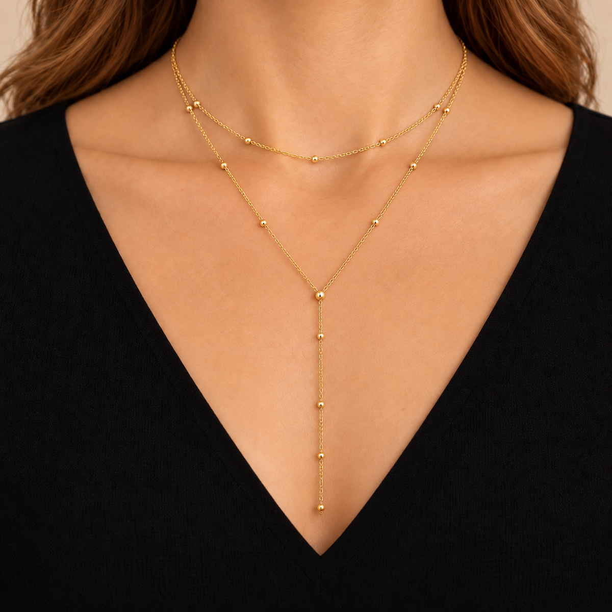Stella — collier double rang doré porté avec décolleté noir