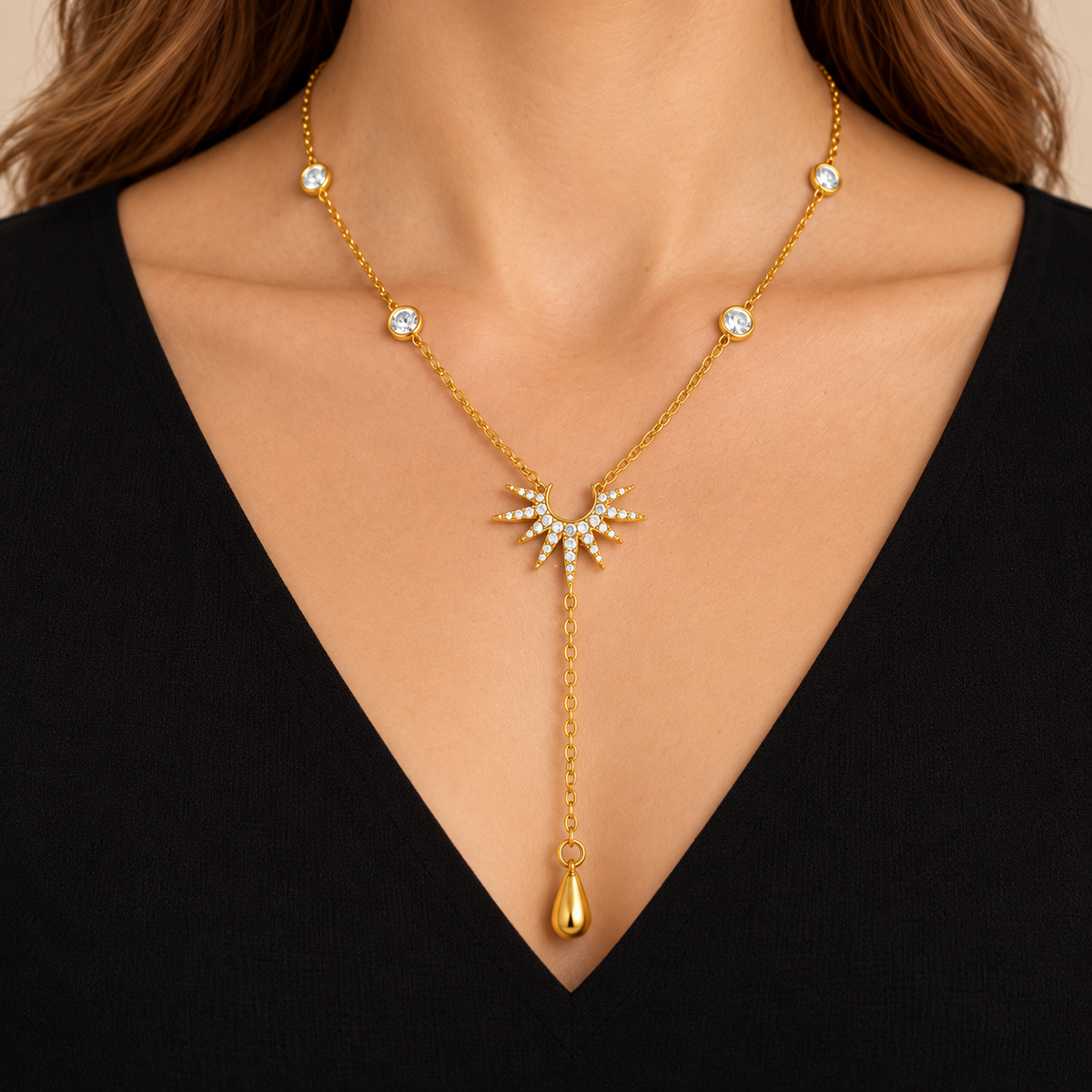 Stella — collier étoile doré porté, gros plan avec décolleté noir