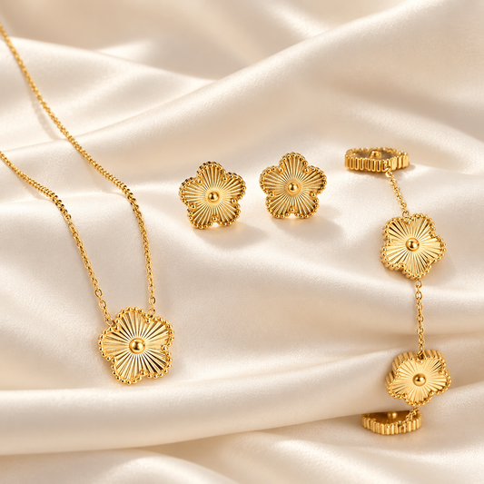 Parure dorée à fleurs : collier, bracelet et boucles sur satin