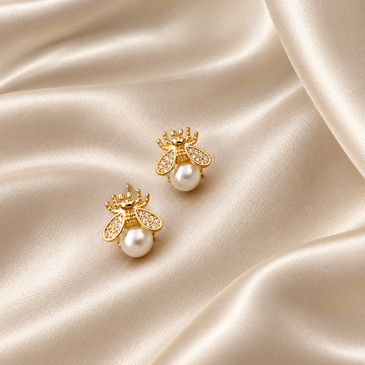 Boucles abeille dorées avec perle ivoire sur satin