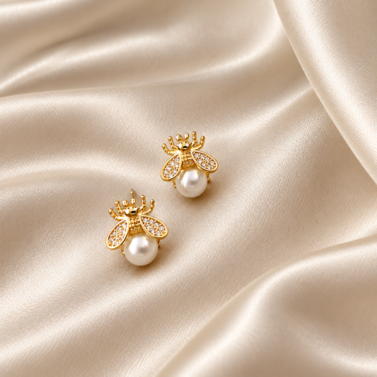 Boucles abeille dorées avec perle ivoire sur satin